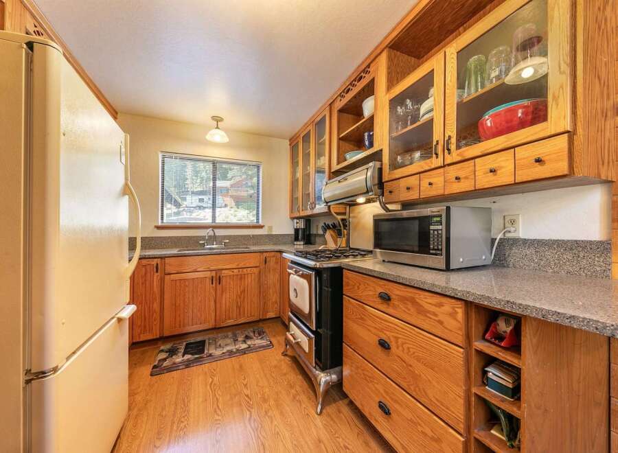 This charming kitchen features warm wooden cabinetry and a classic gas range, perfect for home-cooked meals.