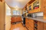 This charming kitchen features warm wooden cabinetry and a classic gas range, perfect for home-cooked meals.