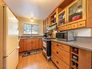 This charming kitchen features warm wooden cabinetry and a classic gas range, perfect for home-cooked meals.