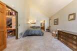 Discover this charming bedroom featuring a comfortable queen-size bed adorned with a luxurious blue and gold damask comforter.