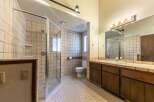 This spacious bathroom features a large, glass-enclosed shower with tiled walls and a built-in shelf.