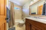 This bathroom features a classic design with a bathtub and shower combo, complemented by beige tiled walls.
