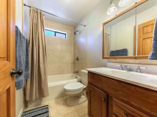 This bathroom features a classic design with a bathtub and shower combo, complemented by beige tiled walls.