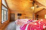 Experience rustic charm in this unique loft bedroom, featuring a cozy bed adorned with vibrant, patterned bedding.