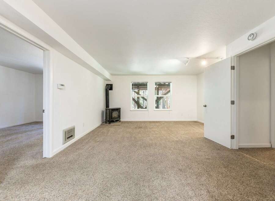 This spacious living area features a cozy wood-burning stove, perfect for chilly evenings.