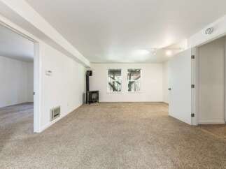 This spacious living area features a cozy wood-burning stove, perfect for chilly evenings.