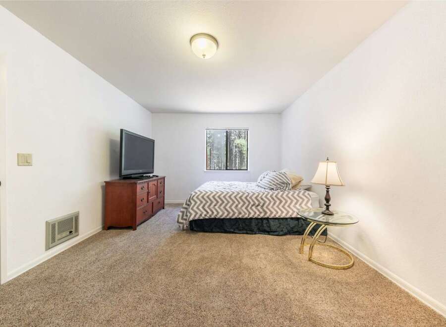 This cozy bedroom features a comfortable bed with a chevron-patterned comforter, perfect for a restful night's sleep.