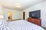 This cozy bedroom features a comfortable bed with a stylish gray and white chevron comforter, perfect for relaxation.