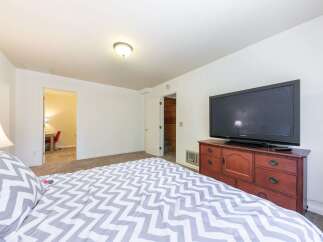 This cozy bedroom features a comfortable bed with a stylish gray and white chevron comforter, perfect for relaxation.