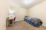 This cozy bedroom features a comfortable twin bed with stylish grey and blue bedding, perfect for a guest room or a child's space.