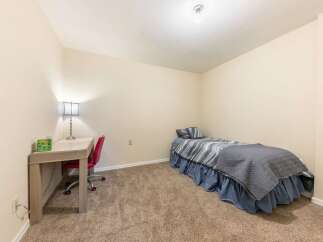 This cozy bedroom features a comfortable twin bed with stylish grey and blue bedding, perfect for a guest room or a child's space.