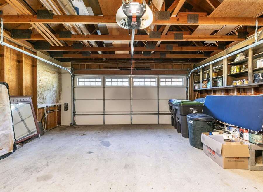 This spacious garage offers ample storage with built-in shelving units, perfect for organizing tools and supplies.