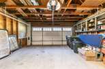 This spacious garage offers ample storage with built-in shelving units, perfect for organizing tools and supplies.