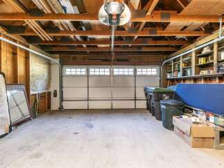 This spacious garage offers ample storage with built-in shelving units, perfect for organizing tools and supplies.