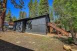 Nestled amongst tall pine trees, this dark-paneled home offers a unique mountain retreat.