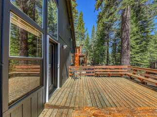 Enjoy the serene mountain setting from this expansive wooden deck, perfect for outdoor entertaining or quiet relaxation.