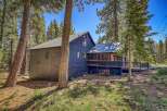 Nestled amidst towering pine trees, this charming dark blue home offers a serene mountain retreat.