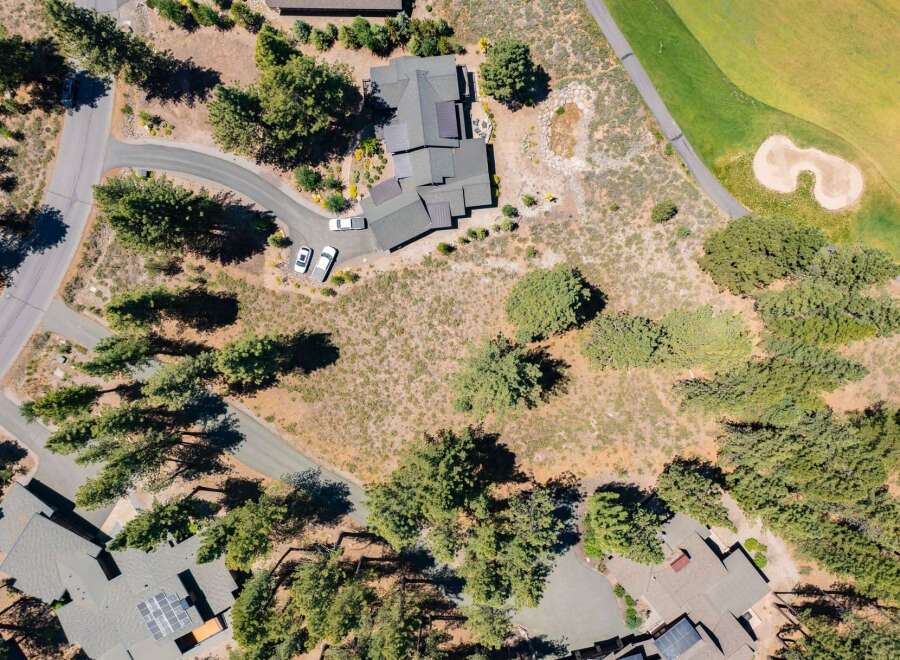 Discover this stunning property featuring a modern home with solar panels, nestled amidst mature trees.