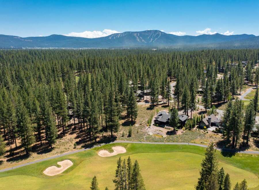 Experience luxury living nestled amidst a pristine pine forest, offering breathtaking mountain views.