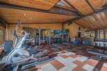 Elevate your fitness routine in this well-equipped home gym, featuring a variety of cardio machines like ellipticals and a full-scale weight training station.