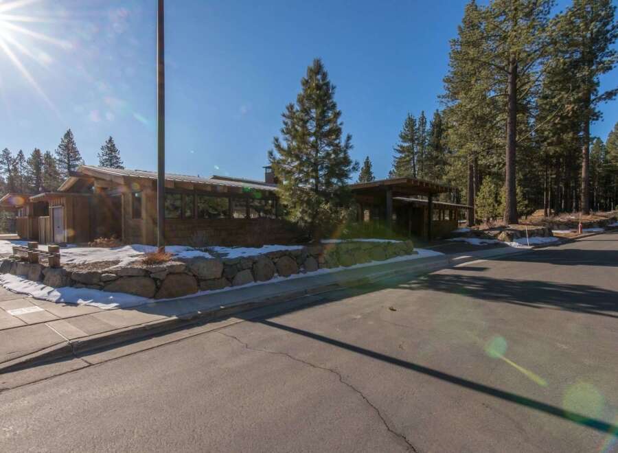 Nestled amidst towering pine trees, this charming wooden structure offers a unique architectural style.