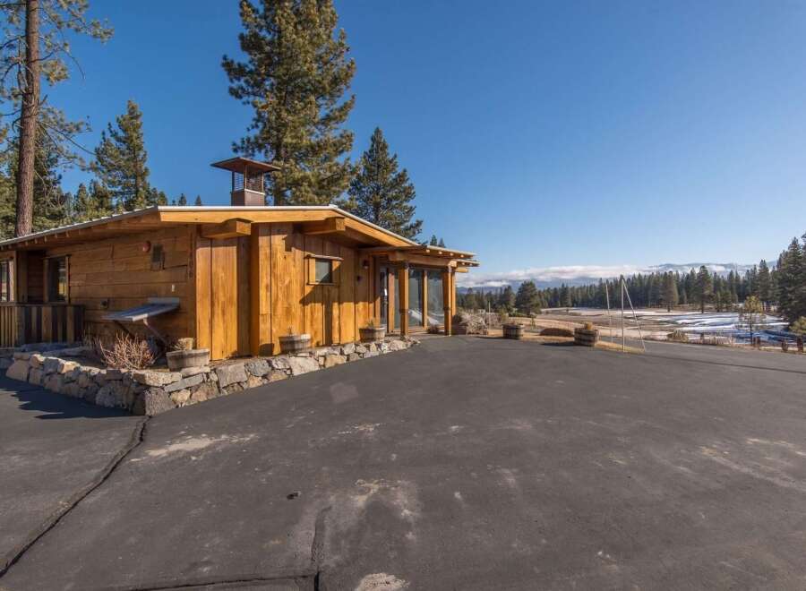Experience rustic charm in this beautifully crafted wooden home, nestled amidst towering pine trees.