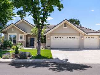 Discover this charming single-story home featuring a welcoming facade with stone accents and a well-maintained lawn.