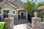 Welcome guests to this charming home with a striking stone-accented entrance, featuring elegant lamp posts and a welcoming dark blue front door.
