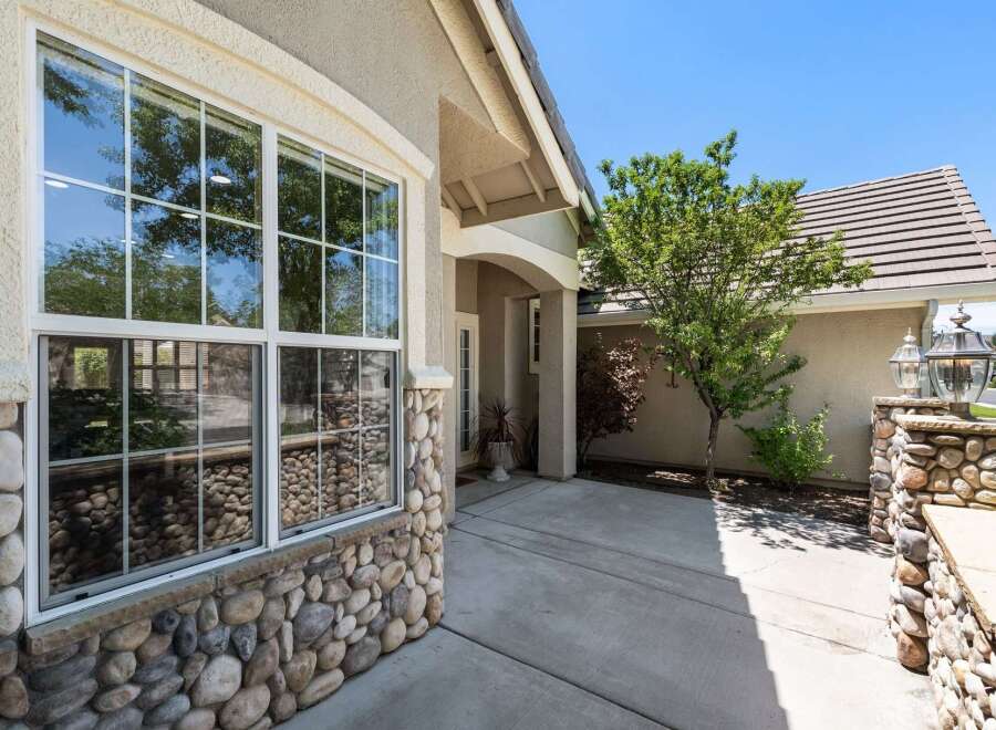 This charming home features a beautiful stone-accented exterior, complemented by a large, multi-pane window that offers abundant natural light.