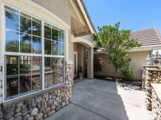 This charming home features a beautiful stone-accented exterior, complemented by a large, multi-pane window that offers abundant natural light.