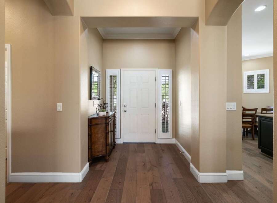 Step into a welcoming entryway featuring a classic white front door flanked by elegant sidelights.