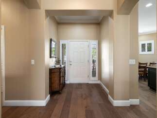 Step into a welcoming entryway featuring a classic white front door flanked by elegant sidelights.