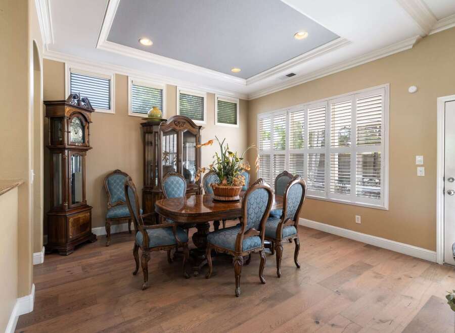This elegant dining room features a grand grandfather clock and a matching china cabinet, perfect for showcasing your finest china.