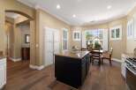 This spacious kitchen boasts a large island with granite countertops, perfect for meal preparation and casual dining.