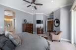 Experience luxury in this master bedroom, featuring a spacious king-sized bed with plush bedding and elegant decorative pillows.