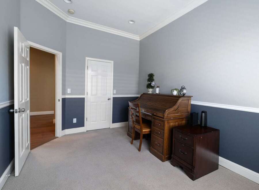 This home office features a classic roll-top desk and a matching file cabinet, perfect for a productive workspace.