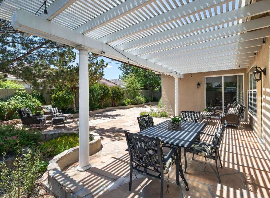 Enjoy outdoor living under this spacious white pergola, offering ample shade for your patio set.