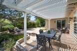 Enjoy outdoor living under this spacious white pergola, offering ample shade for your patio set.