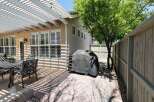 Enjoy outdoor living with this charming patio featuring a white pergola providing ample shade.