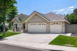 This charming single-family home features a welcoming facade with a stone-accented entrance and a spacious three-car garage.