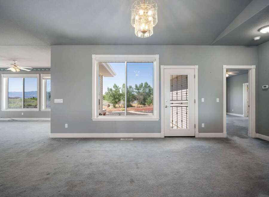 Step into this spacious living area featuring a large window with scenic views and a glass-paneled door leading outdoors.