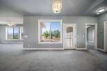 Step into this spacious living area featuring a large window with scenic views and a glass-paneled door leading outdoors.