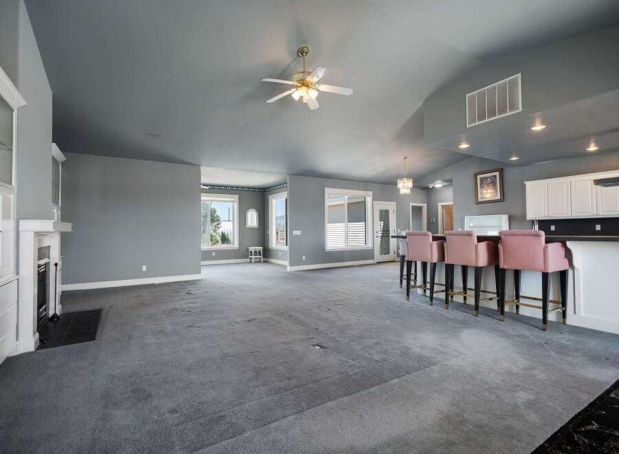 This spacious open-concept living area features a vaulted ceiling with a ceiling fan and recessed lighting, creating an airy and inviting atmosphere.