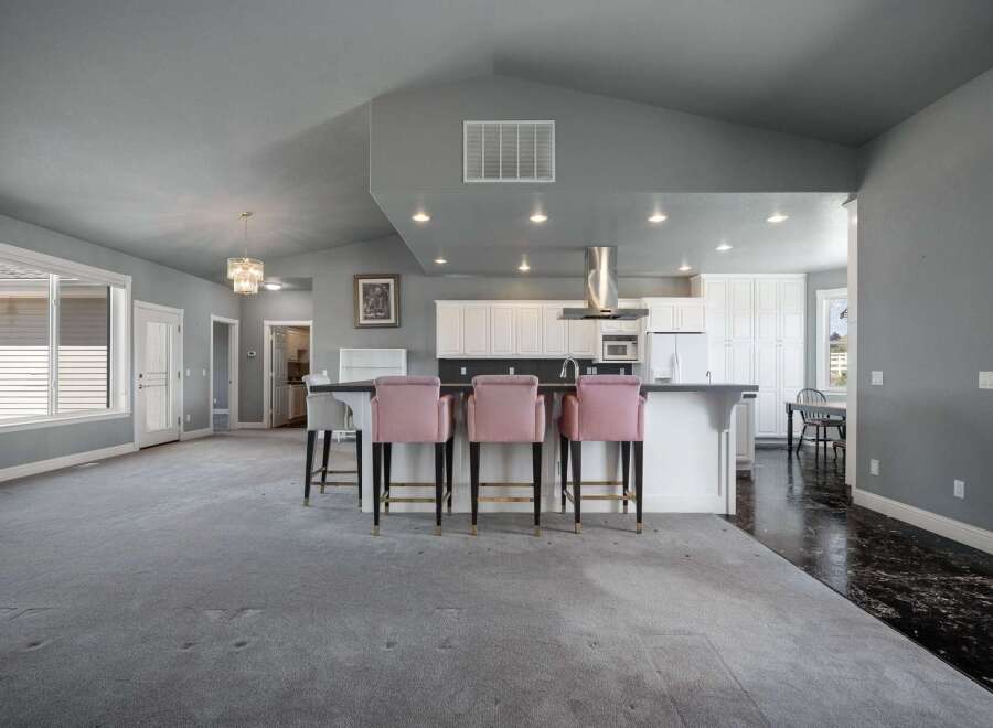 Experience modern living in this spacious open-concept home featuring a stunning kitchen with ample white cabinetry and a sleek island perfect for entertaining.