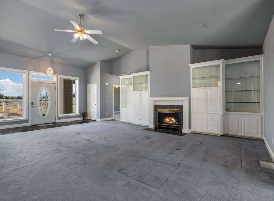 Step into this spacious living room featuring a cozy fireplace and elegant built-in display cabinets.