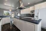 This spacious kitchen boasts a large central island with a gas stovetop, perfect for culinary enthusiasts.