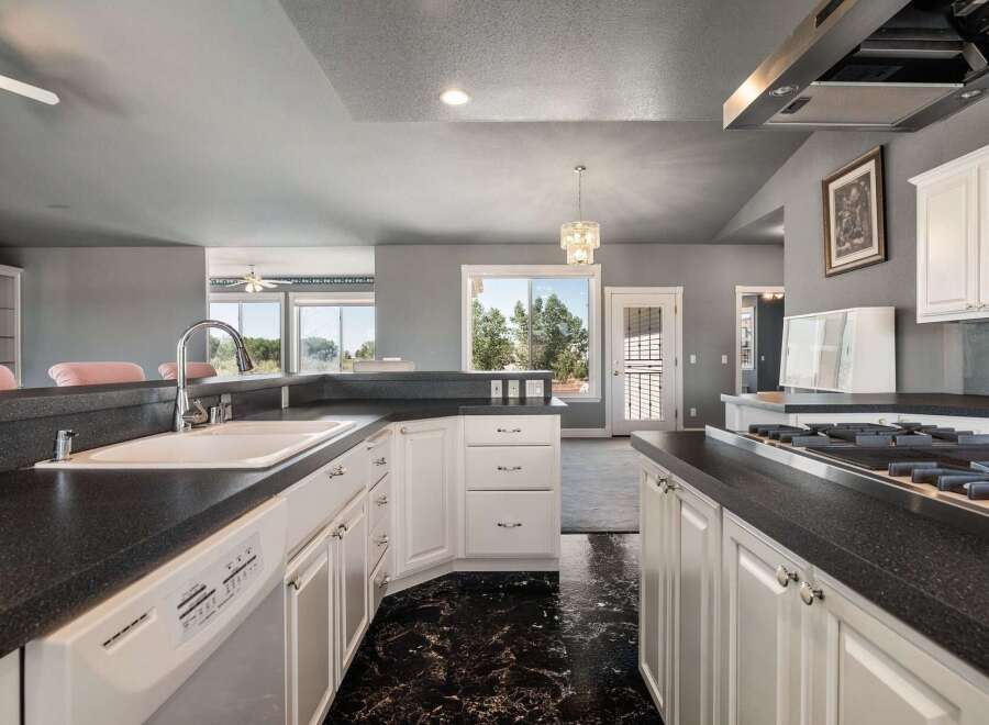 This spacious kitchen features a large sink, a gas range, and ample cabinet space, perfect for any home chef.