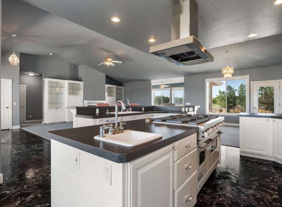 This spacious kitchen boasts a large island with a sink and a professional-grade gas range, perfect for culinary enthusiasts.