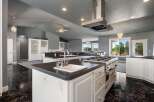 This spacious kitchen boasts a large island with a sink and a professional-grade gas range, perfect for culinary enthusiasts.