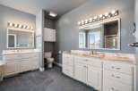 This spacious bathroom features a double vanity with ample counter space and storage, perfect for any household.